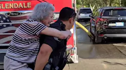 A Glendale police officer carries a resident to safety during a nursing home fire