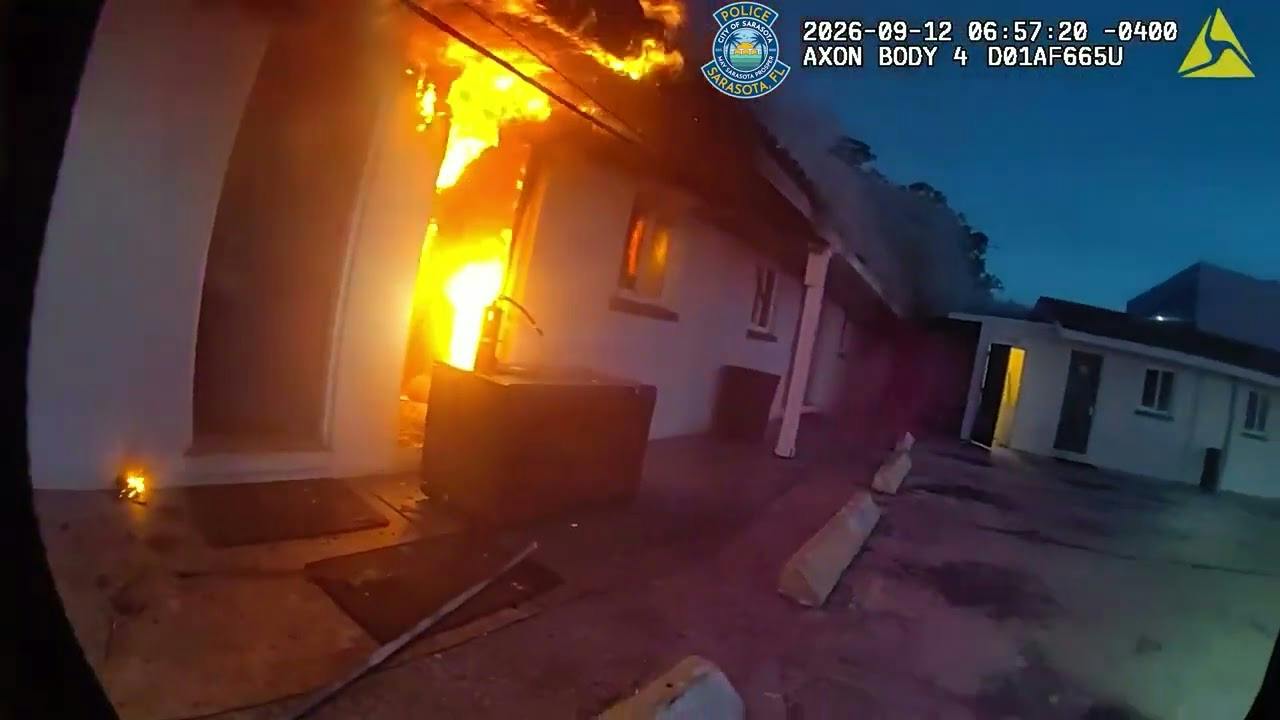 A Sarasota police officer races to a motel fire to help evacuate residents
