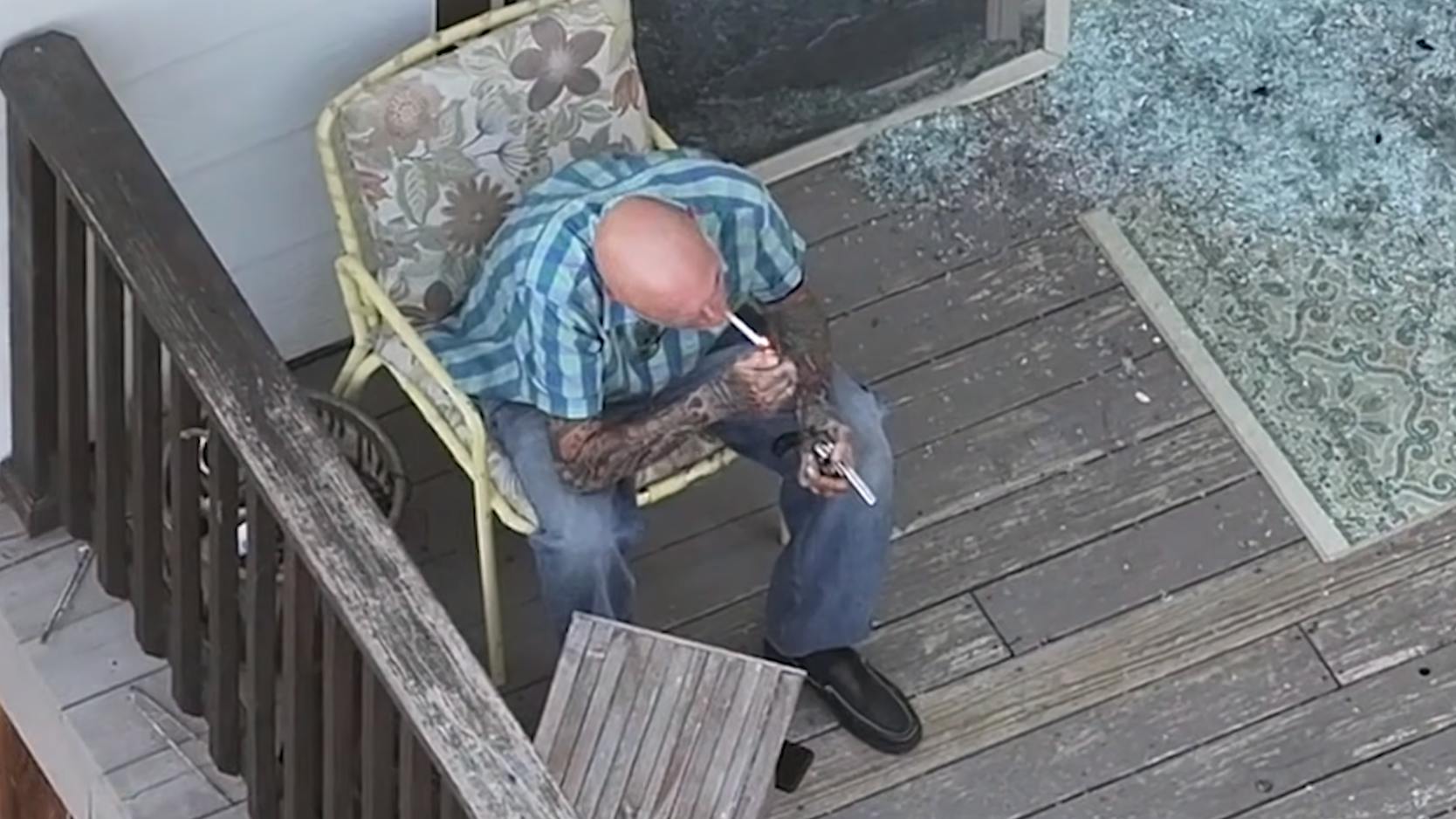 An armed suspect sits on a porch during a standoff with Loveland SWAT memgbers