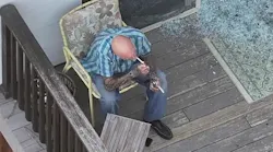 An armed suspect sits on a porch during a standoff with Loveland SWAT memgbers