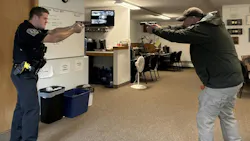 A training instructor and a trainee police officer participate in a head-to-head dry-fire exercise