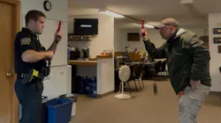 An instructor and trainee police officer participate in a head-to-head reloading exercise