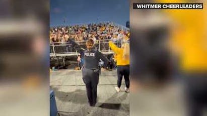Toledo Police Officer Brooklyn Esser performs a cheerleading routine at her former high school during a football game.