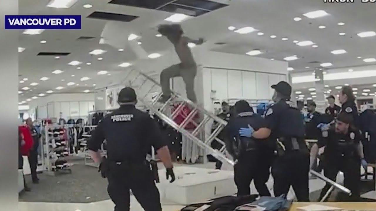 A suspect crawing through a Macy's store ceiling falls onto a mattress after Vancouver police officers pull away a ladder