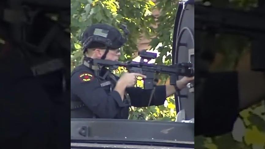 An Erie police officer at the scene of a mass shooting that left nine people, including two children and the gunman