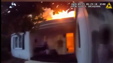 An Aurora police officer helps rescue seven residents from a burning home