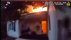 An Aurora police officer helps rescue seven residents from a burning home