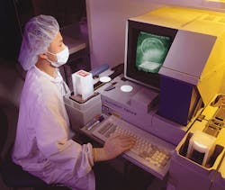 An inspector at Crystal Technology checks wafers that the company produces for acousto-optic components. Test specifications and An inspector at Crystal Technology checks wafers that the company produces for acousto-optic components. Test specifications and