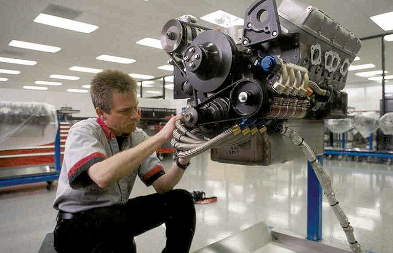 Hendrick Motorsports builds cars for several NASCAR racing teams. Here, a technician makes adjustments on an engine bound for hi