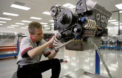 Hendrick Motorsports builds cars for several NASCAR racing teams. Here, a technician makes adjustments on an engine bound for hi