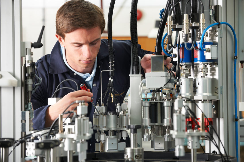 In this photo, an engineer works on complex machinery. Manufacturing&rsquo;s resurgence creates demand for skilled technicians