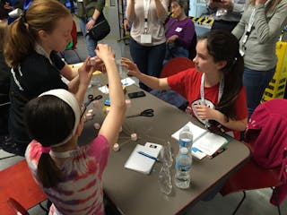 Girls compete to build the tallest tower that will stand on its own.