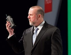 Honeywell's Andy D'Amelio holds a 40-year-old mobile phone to make a point about 40-year-old control systems. Honeywell's Andy D'Amelio holds a 40-year-old mobile phone to make a point about 40-year-old control systems.