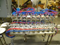 This conveyor-based packaging machine dispenses product to 10 difficult-to-handle oval bottles at a time.