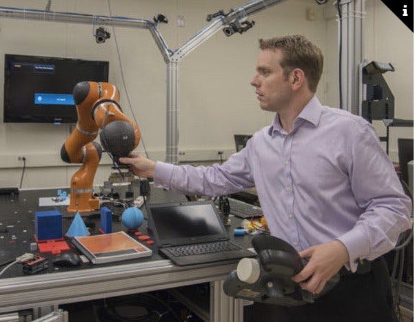 NIST engineer Jeremy Marvel adjusts a robotic arm used to study human-robot interactions. According to a NIST economic study on advanced robotics and automation&mdash;one of four reports on advanced manufacturing&mdash;Marvel&rsquo;s work is the type of research needed to fortify and facilitate this emerging field. Credit: F. Webber/NIST