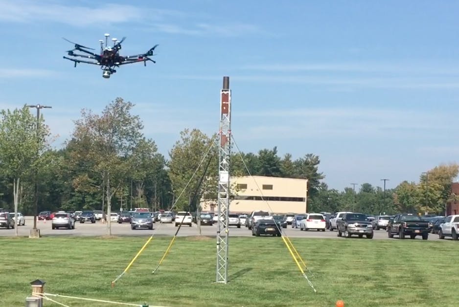 At an outdoor test site at GE Global Research, a drone flies around a small tower to create a 3D model of the asset. At an outdoor test site at GE Global Research, a drone flies around a small tower to create a 3D model of the asset.