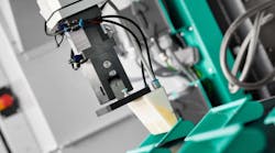 The 3D-printed gripper attached to the robot arm is designed to remove specially designed injection molded parts. Source: Arburg