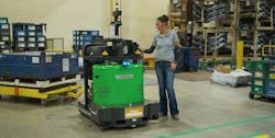 A warehouse employee programs a Vecna Robotics ATG Autonomous Tugger for its next task on the shop floor. Source: Vecna Robotics