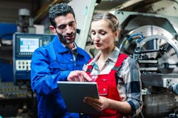 manufacturing workers reviewing tasks to be performed manufacturing workers reviewing tasks to be performed