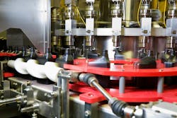 Oil dispensed on a motion controlled fill line into quart bottles at a lubricant manufacturing facility. Oil dispensed on a motion controlled fill line into quart bottles at a lubricant manufacturing facility.