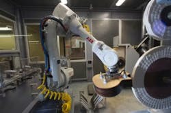 An ABB IRB 4600 robot positions a guitar body against the buffing wheel. An ABB IRB 4600 robot positions a guitar body against the buffing wheel.