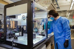 lab technician working with Opentrons system. lab technician working with Opentrons system.