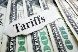 The word 'Tariffs' typed on a scrap of paper laid atop several $100 bills The word 'Tariffs' typed on a scrap of paper laid atop several $100 bills